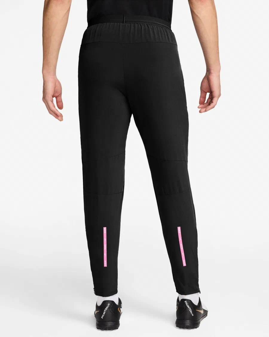 Pantalon Run du PSG noir vu de dos, bandes roses Nike Run sur les mollets et zips aux chevilles