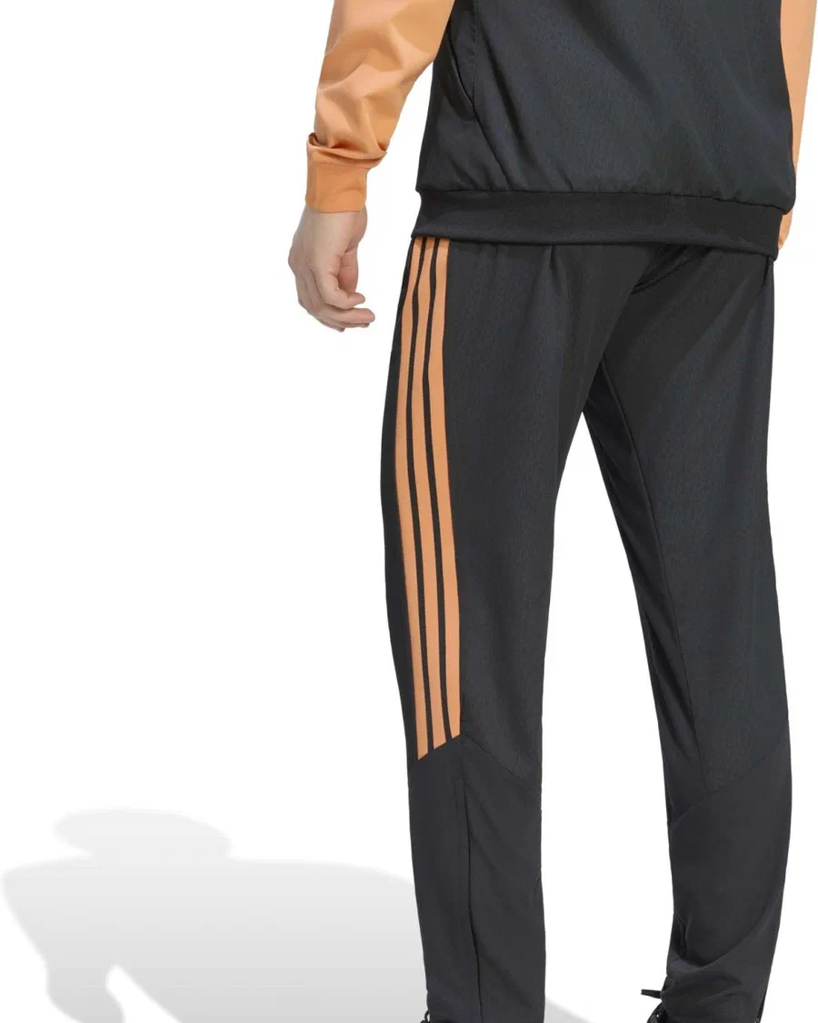 Pantalon tissé Arsenal noir à bandes orange porté sous une veste imperméable